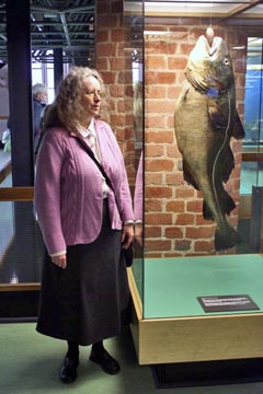 Stralsund, Meeresmuseum, Claudia Tanck neben hängendem Fisch Stralsund, Meeresmuseum, Claudia Tanck neben hängendem Fisch